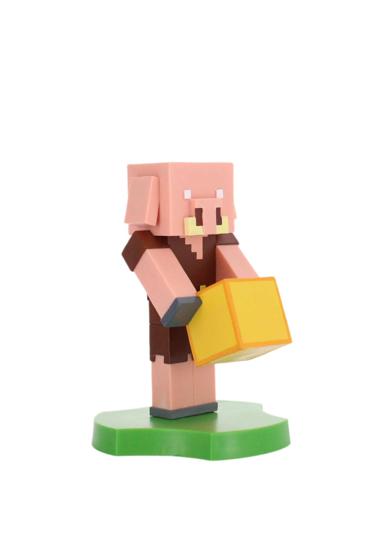 Eine Minecraft-Schweinfigur hält einen gelben Block. Sie steht auf einem grünen Sockel vor weißem Hintergrund.