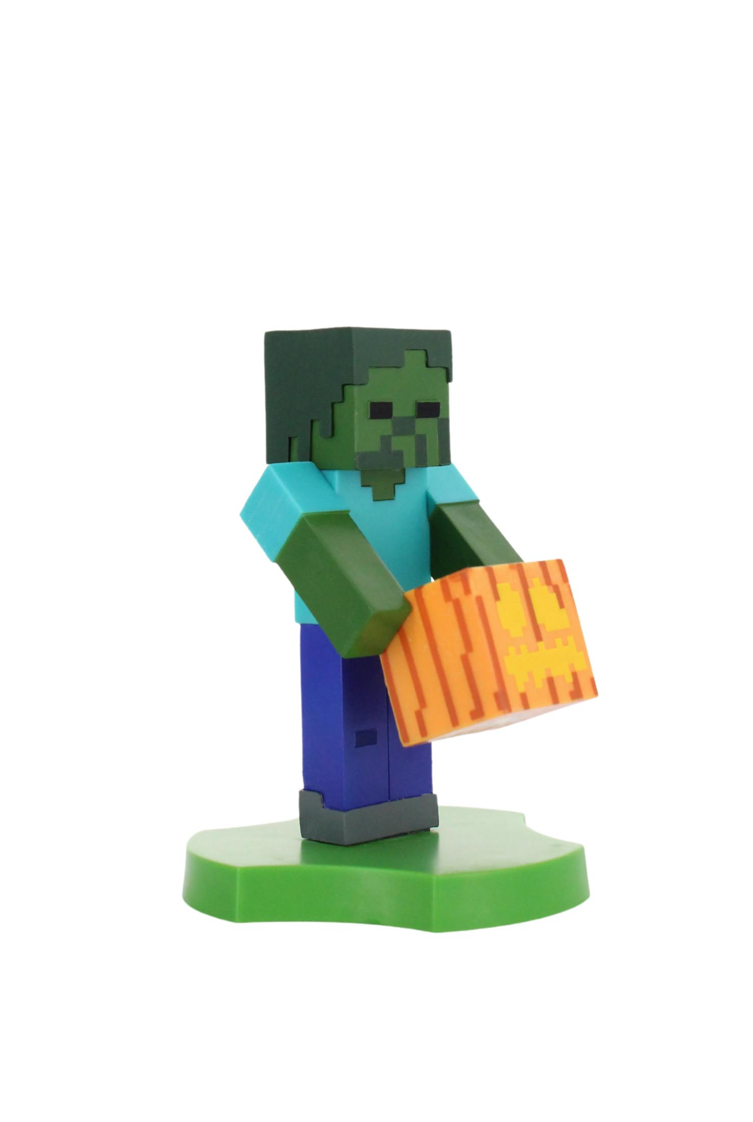 Eine Minecraft-Zombie-Figur hält einen Kürbis. Sie ist grün, blau und lila und steht auf einer grünen Basis vor weißem Hintergrund.