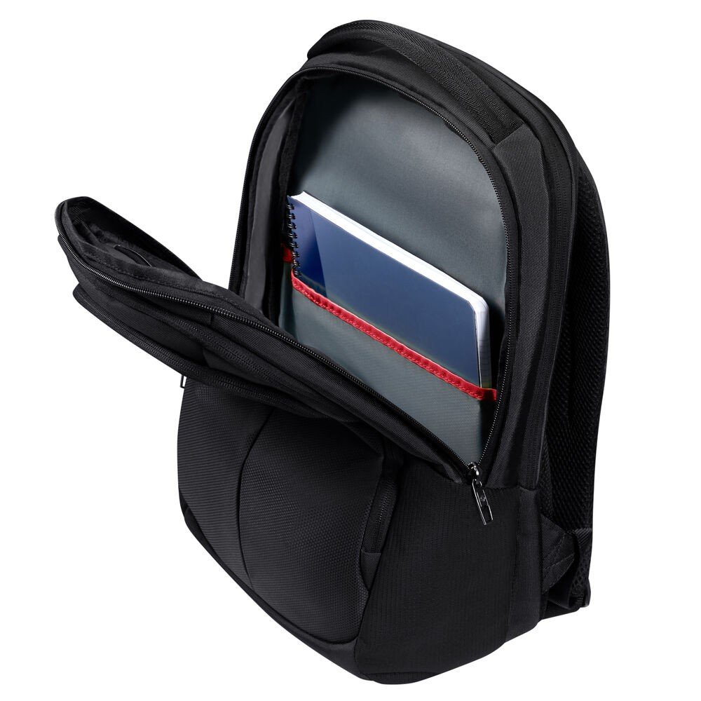 Schwarzer Rucksack mit offenen Fächern. Im Inneren ist ein Notizbuch mit blauem Umschlag zu sehen. Der Rucksack hat einen roten Riemen.