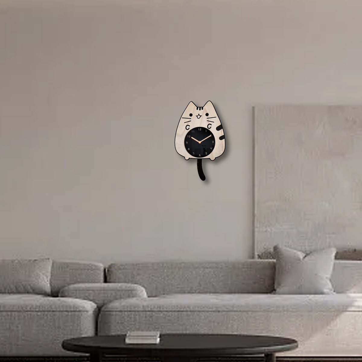 Katzenförmige Uhr an der Wand, mit schwarzem Zifferblatt. Darunter ein graues Sofa und ein schwarzer Tisch.