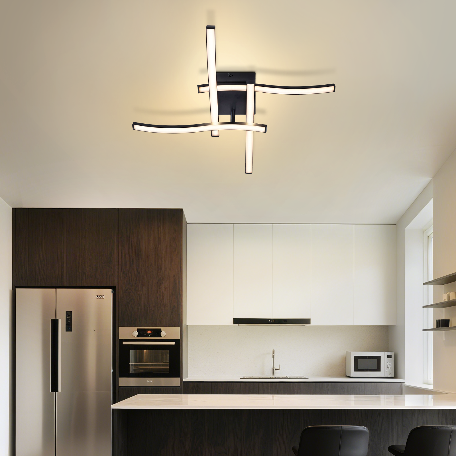 Moderne Küche mit Schwarz-Weiß-Design, Deckenleuchte, Edelstahlgeräten und Bar.