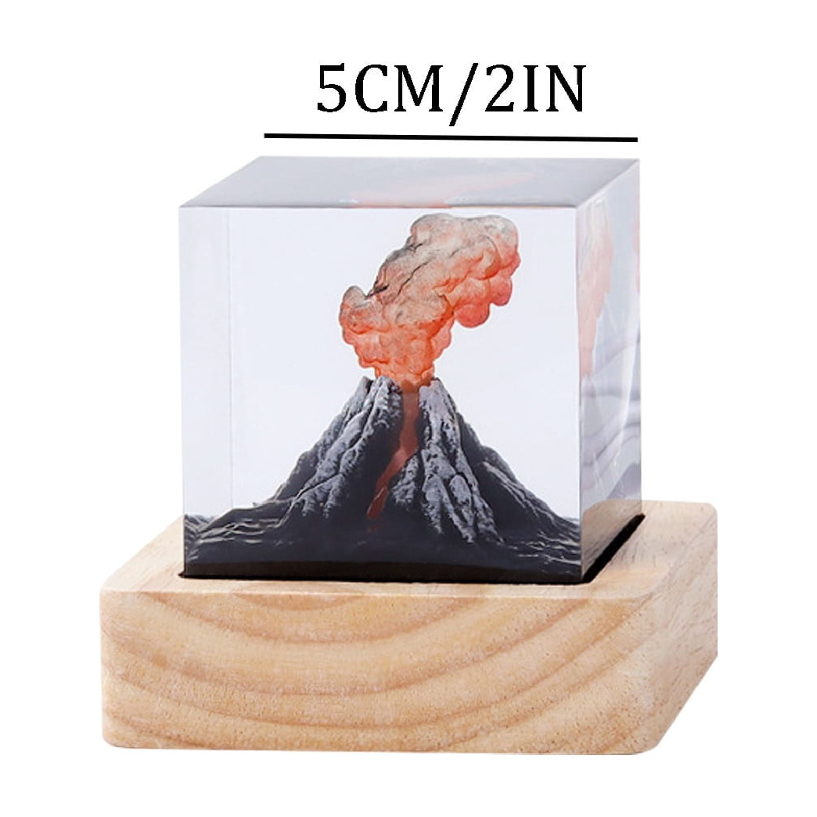 Ein klarer Würfel enthält ein Vulkanmodell auf einem Holzsockel. Der Vulkan bricht mit orangem Rauch aus.