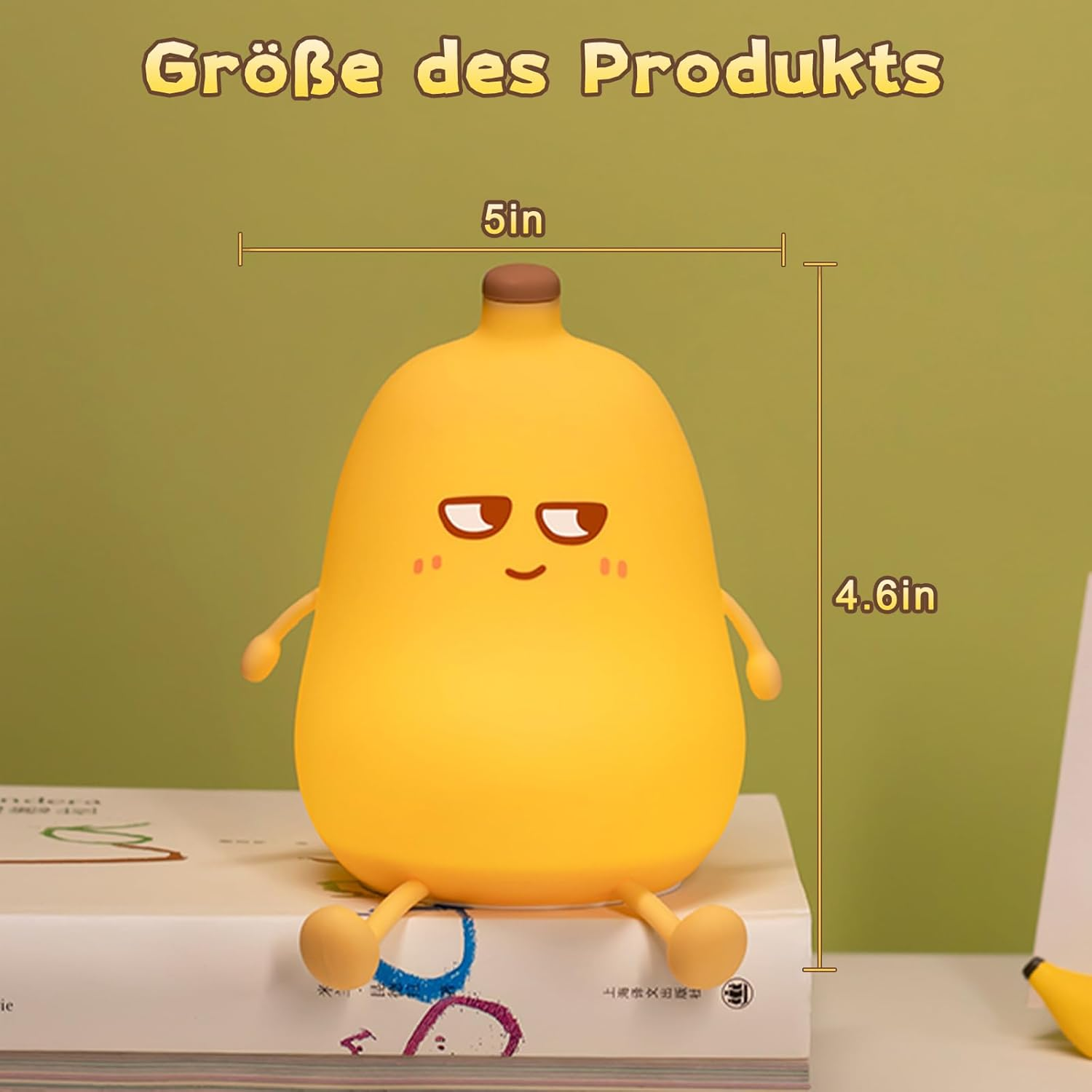 Eine gelbe, bananenförmige Lampe mit Armen und Beinen, die auf einem Buch sitzt. Der Text oben lautet 'Größe des Produkts' und die Maße sind angegeben.