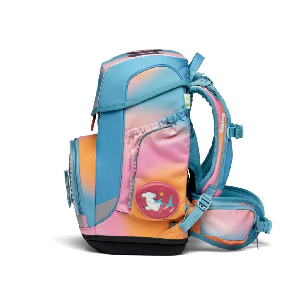Ein farbenfroher Rucksack mit blauem, rosa- und orangefarbenem Farbverlauf. Er hat ein Hai-Abzeichen und eine schwarze Basis. Der Rucksack steht auf weißem Untergrund.