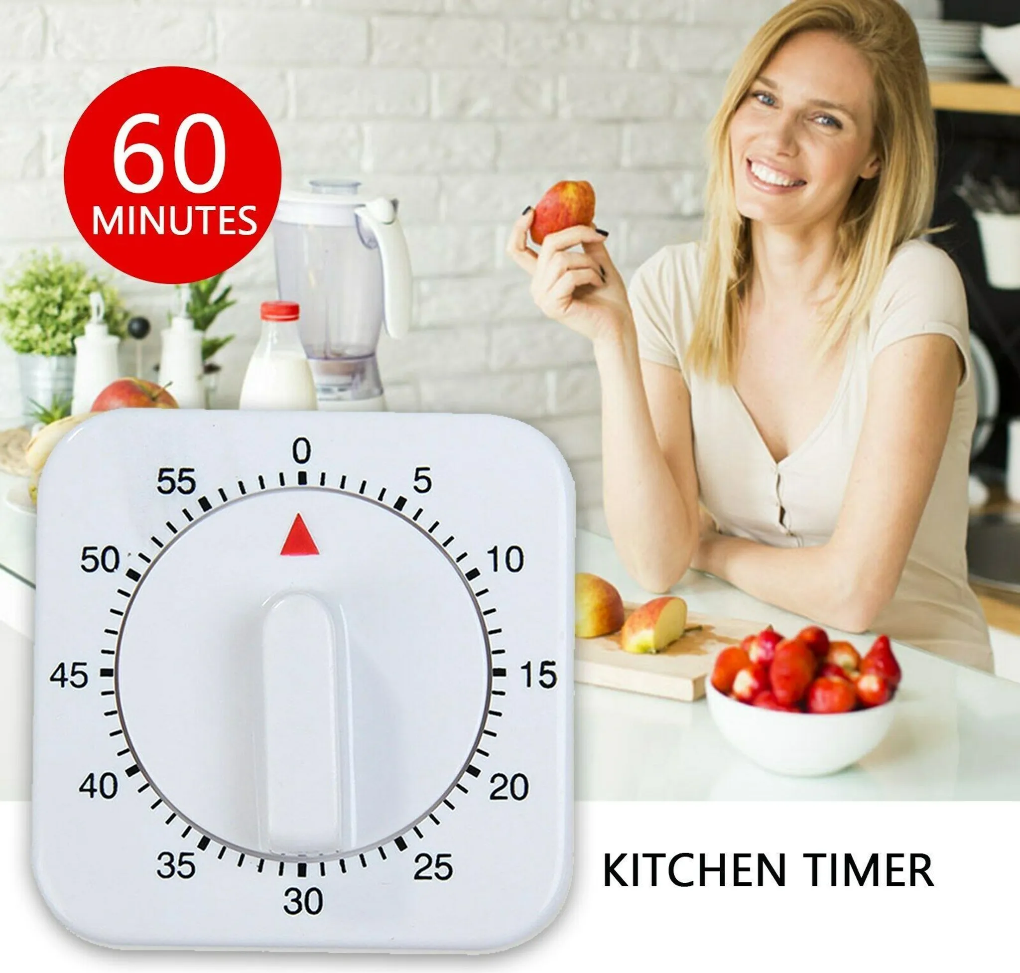 Eine Frau lächelt in einer Küche mit einem Timer, Obst und einem Mixer auf der Theke.