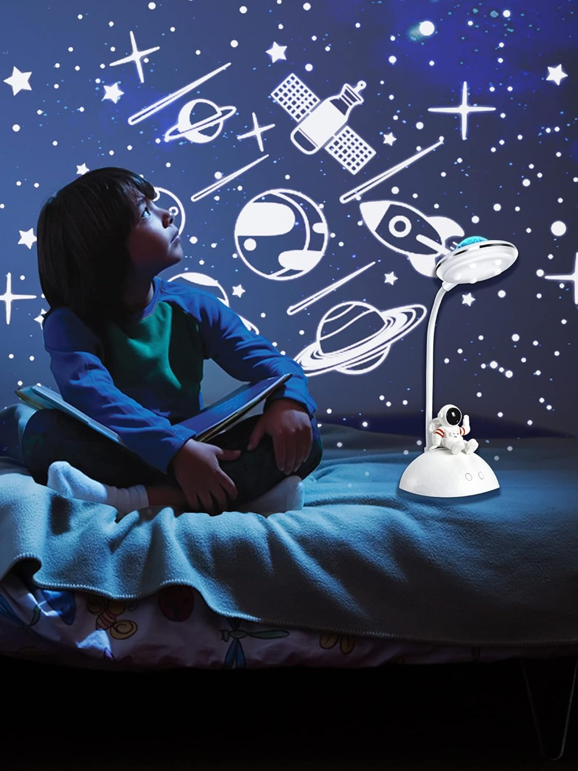 Ein Kind blickt auf eine Sternenhimmelprojektion. Eine Weltraumlampe steht auf dem Bett. Planeten und Sterne sind an der Wand zu sehen.