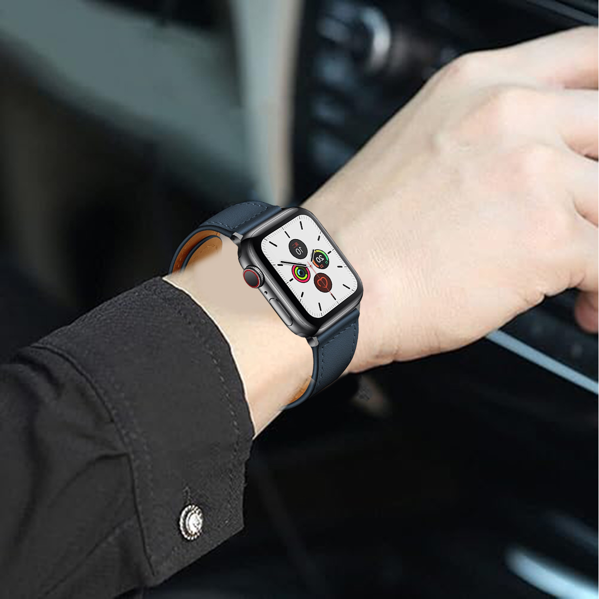 Eine Person, die eine Smartwatch mit blauem Lederarmband trägt. Das Zifferblatt zeigt Zeit- und Aktivitätsindikatoren. Die Person scheint zu fahren.