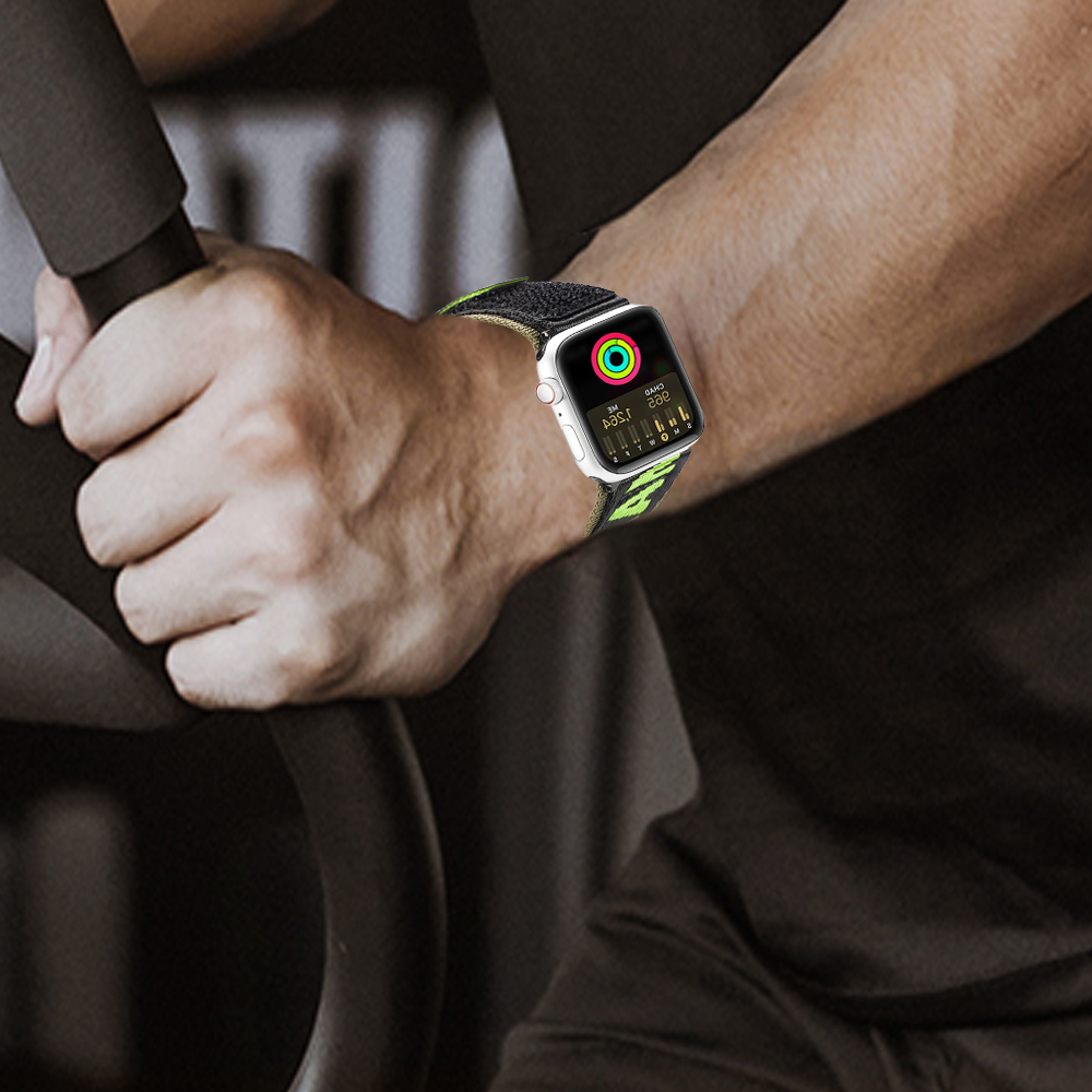 Eine Person trägt eine Smartwatch mit einem schwarz-grünen Armband. Die Uhr zeigt Trainingsdaten an. Die Person hält einen Griff.