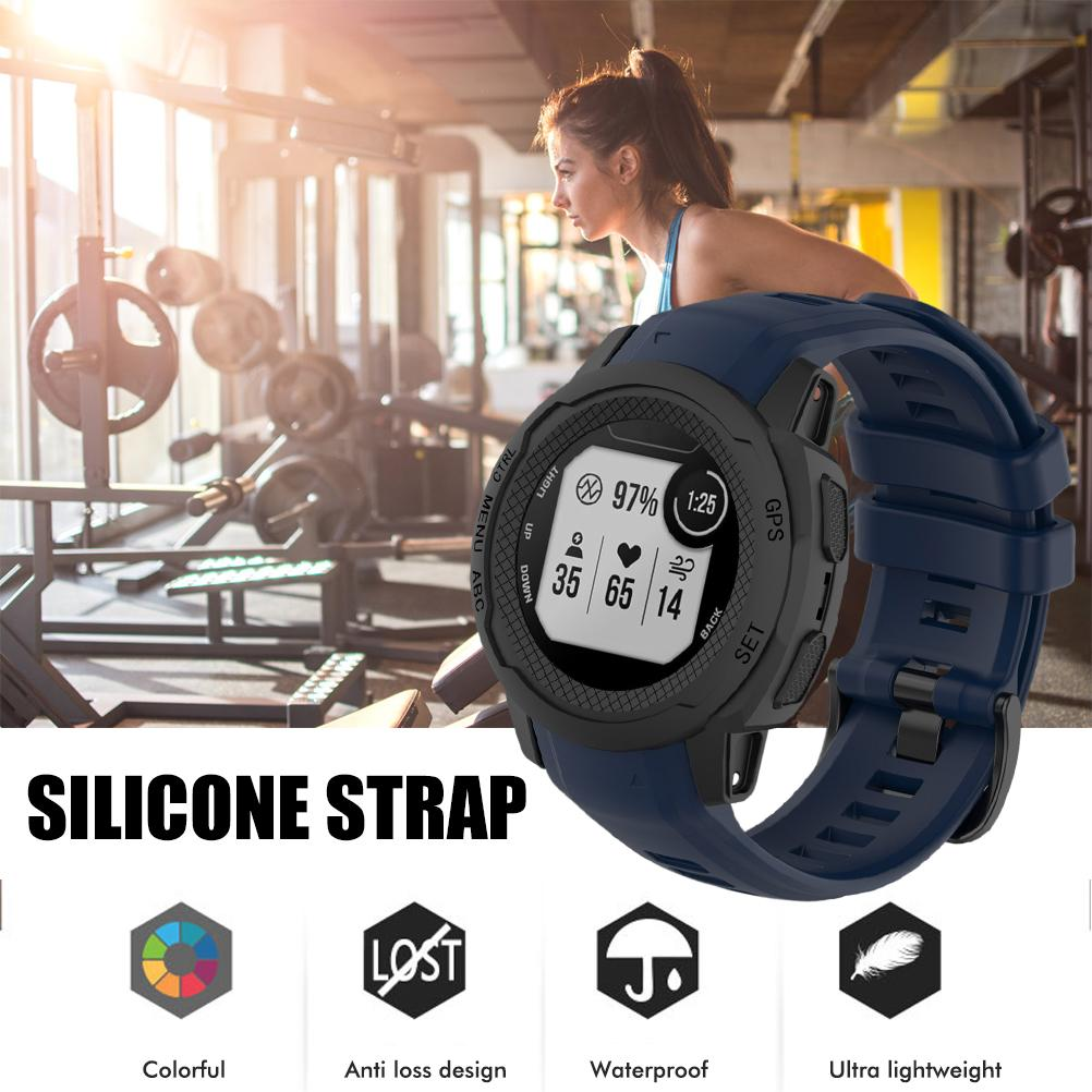 Eine Fitnessuhr mit blauem Silikonarmband wird gezeigt, im Hintergrund eine Frau in einem Fitnessstudio. Die Uhr zeigt Daten.