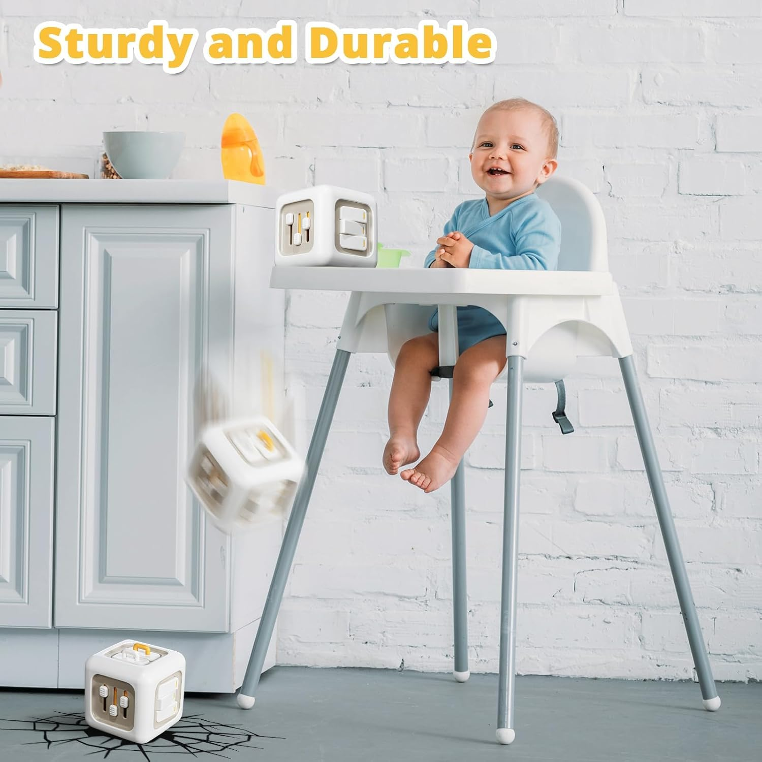 Ein Baby sitzt in einem Hochstuhl. Weiße Würfel fallen. Der Text "Sturdy and Durable" steht über dem Kopf des Babys.