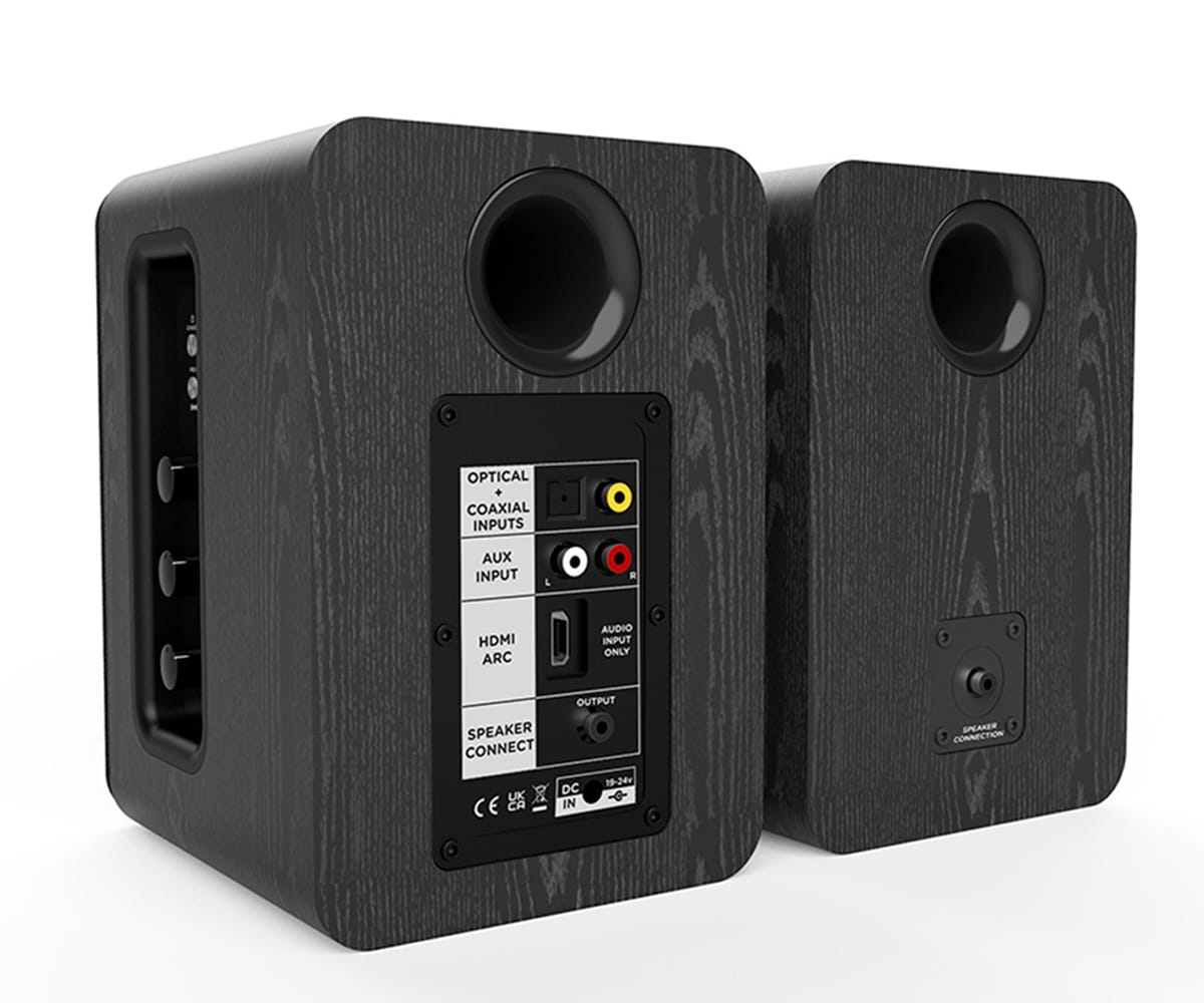 Due altoparlanti in legno nero con porte di ingresso. Etichette: Ottico, Coassiale, Aux, HDMI, Output e Speaker Connect.
