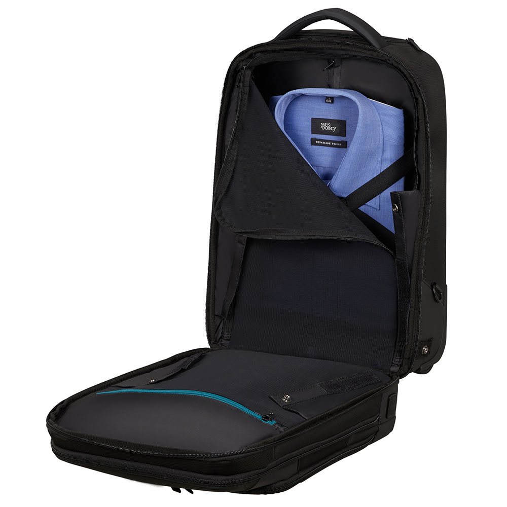 Offener schwarzer Rucksack mit blauem Hemd. Das untere Fach ist offen und zeigt einen türkisfarbenen Reißverschluss.