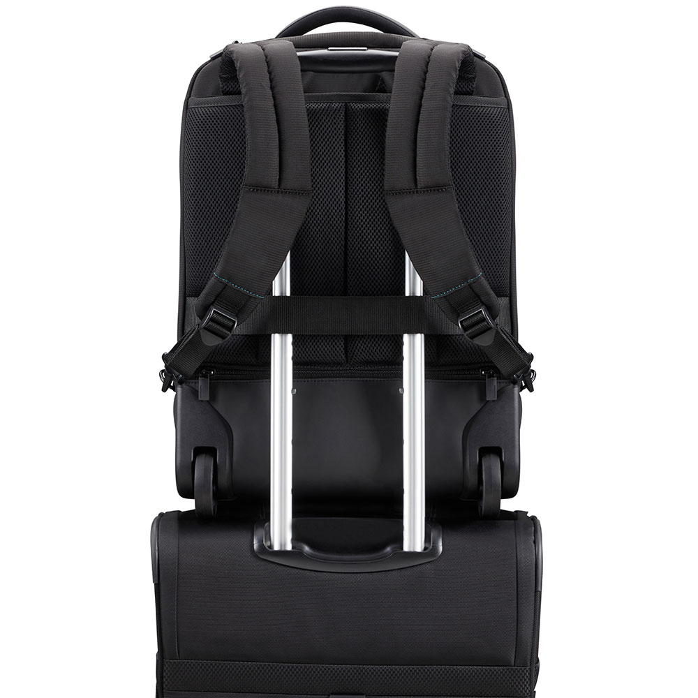 Ein schwarzer Rucksack auf einem schwarzen Koffer. Der Rucksack hat Träger und einen Griff. Der Koffer hat einen ausziehbaren Griff und Räder.