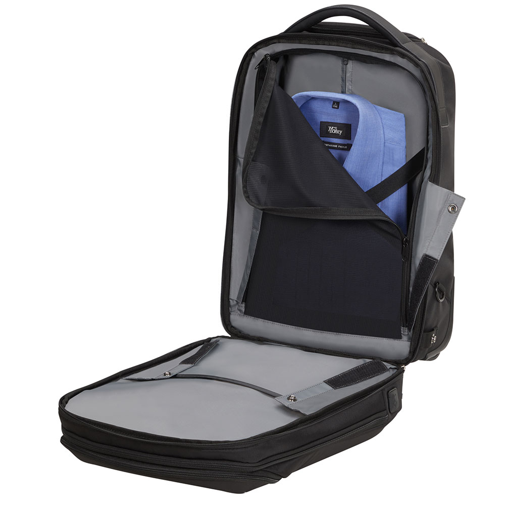 Offener schwarzer Rucksack mit blauem Hemd im Inneren. Das untere Fach ist ebenfalls offen. Graue Innenausstattung und schwarzes Äußeres.