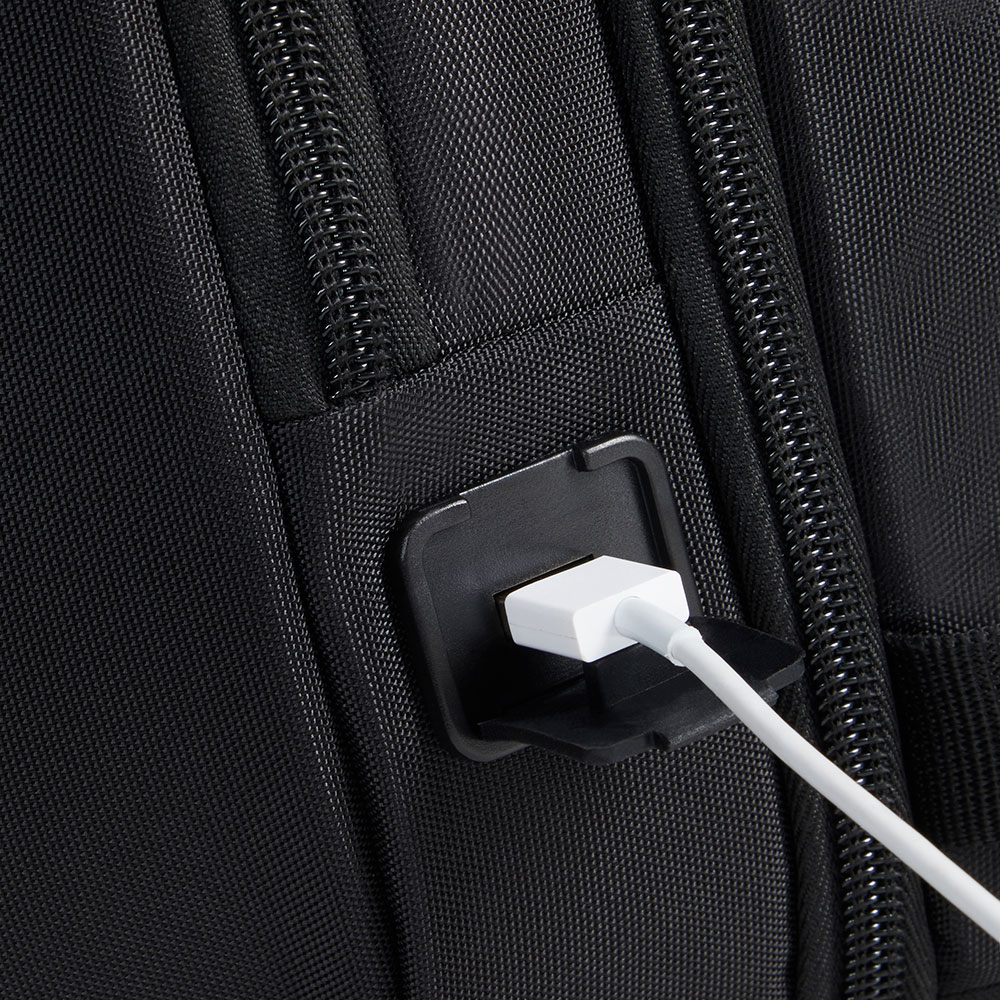 Nahaufnahme eines schwarzen Rucksacks mit einem eingesteckten weißen USB-Kabel. Das Ladegerät befindet sich an einem schwarzen Anschluss.
