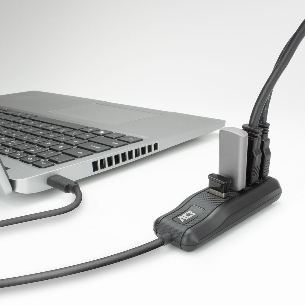 Ein Laptop ist mit einem schwarzen USB-Hub mit mehreren Anschlüssen verbunden. Kabel sind in den Hub eingesteckt. Der Hintergrund ist weiß.
