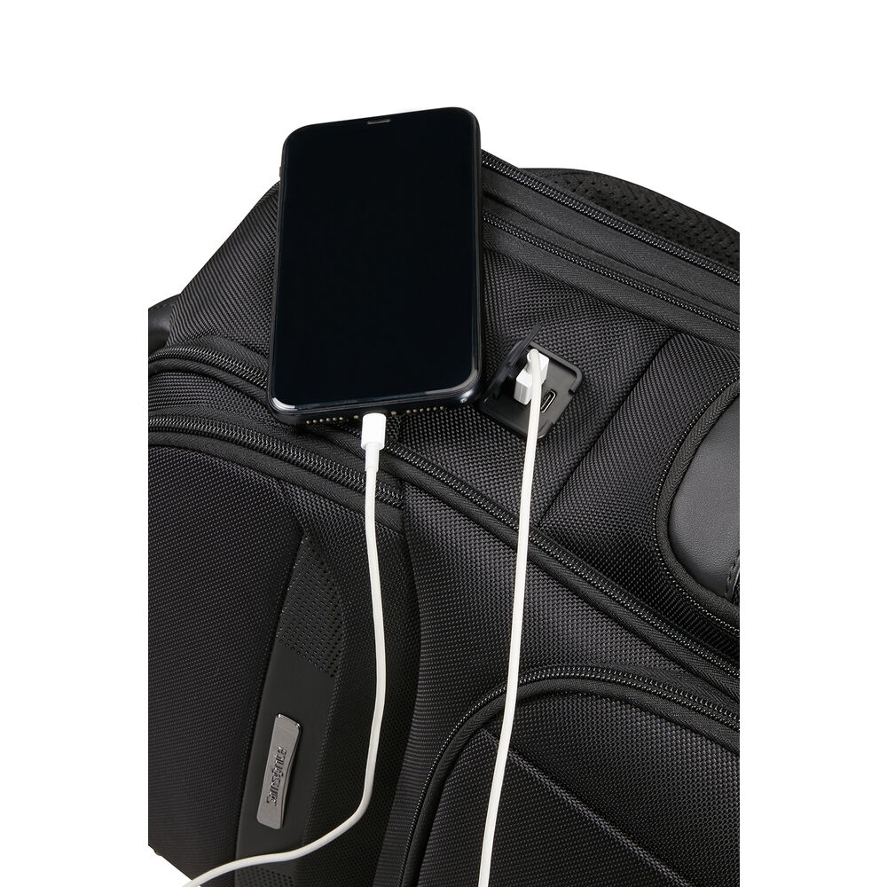Zaino nero con telefono in carica tramite cavo bianco. Un altro cavo bianco è collegato a una porta di ricarica.