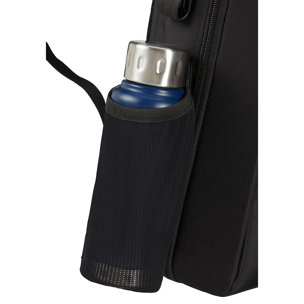 Eine blaue Wasserflasche mit silbernem Deckel in einer schwarzen Netztasche auf einem schwarzen Rucksack. Der Hintergrund ist ebenfalls schwarz.