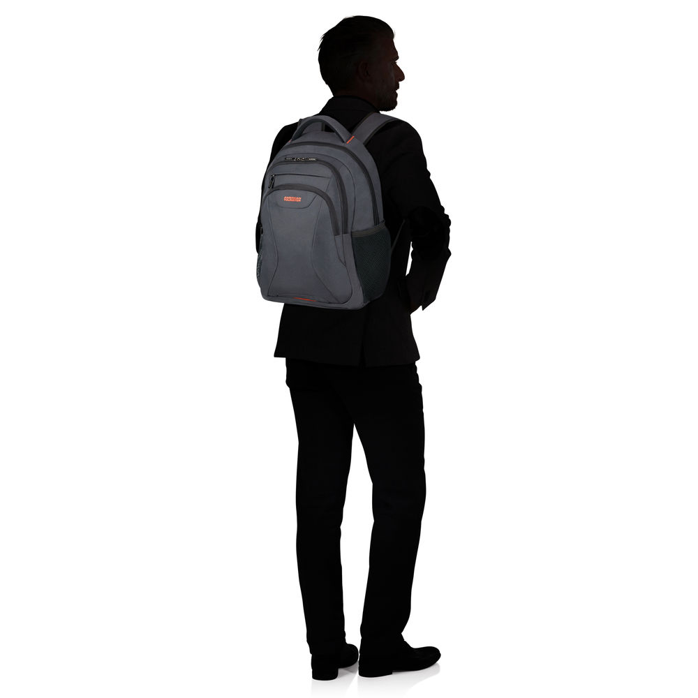 Ein Mann im Anzug steht mit dem Rücken zum Betrachter und trägt einen grauen Rucksack. Der Hintergrund ist weiß.