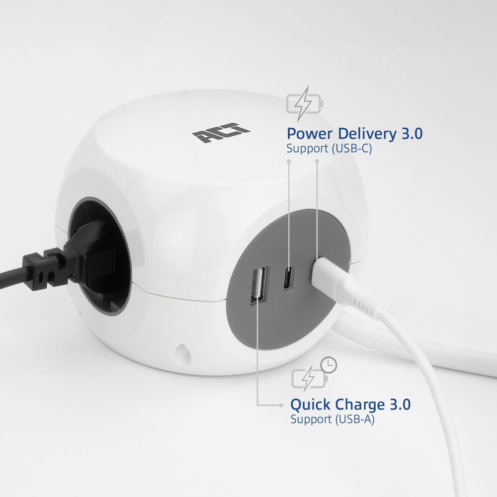 A white, cube-shaped power adapter with black and white cables plugged in. It has USB-A and USB-C ports with labels for power delivery.