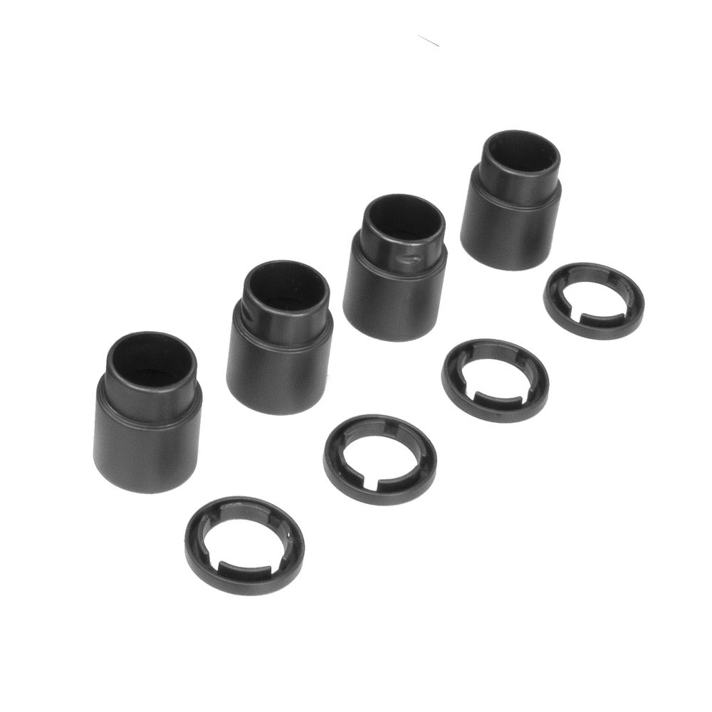 Plusieurs pièces circulaires et cylindres en plastique noir sont disposés sur fond blanc. Les cylindres ont des dessus ouverts.