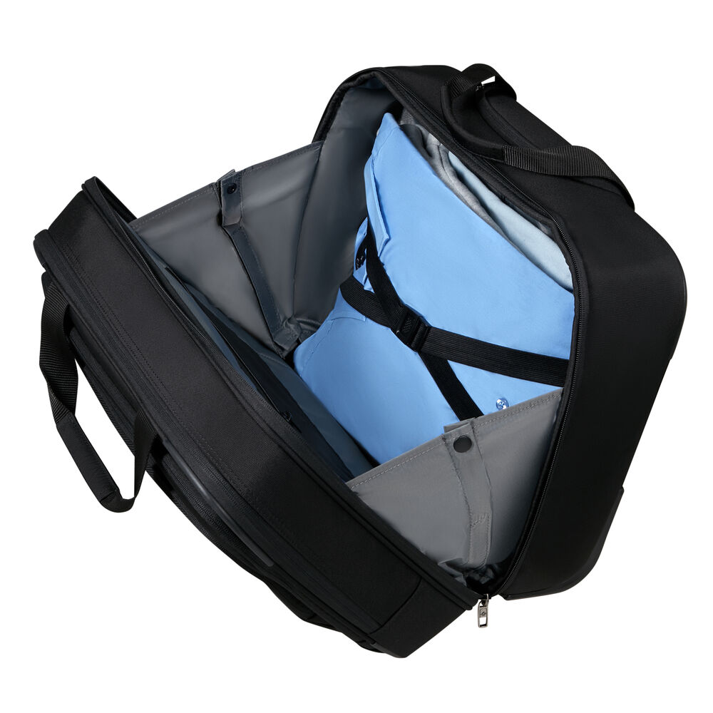 Sac de voyage noir ouvert avec une chemise bleue, des vêtements gris et un compartiment pour ordinateur portable. Le sac est sur fond blanc.
