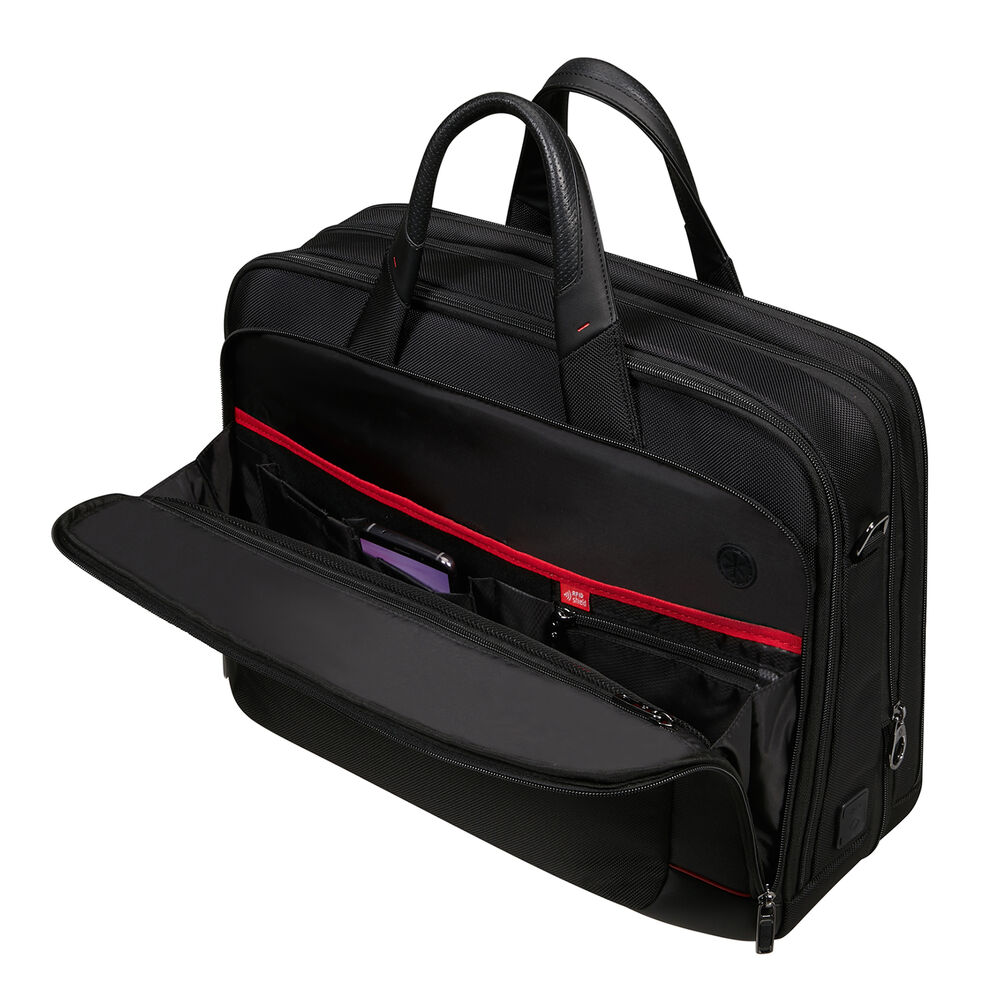 Una valigetta nera con scomparti aperti, rivestimento interno rosso e maniglia. Alcuni oggetti sono visibili nelle tasche.