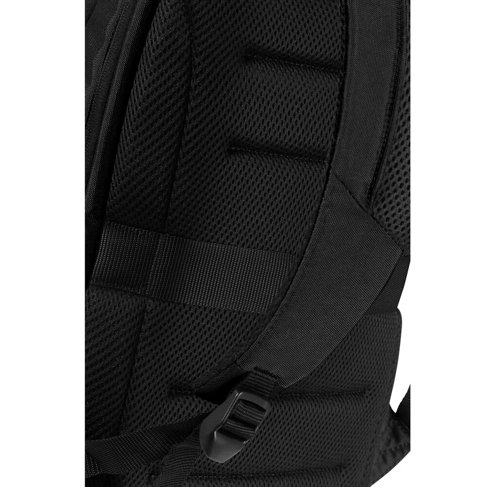 Gros plan sur une sangle de sac à dos noire. Matériau en maille, sections rembourrées et boucle en plastique visibles. L'arrière-plan est flou.
