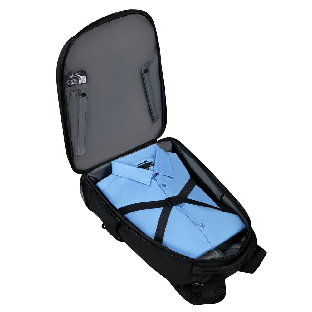 Un sac de voyage noir ouvert révèle une chemise bleu clair fixée par des sangles noires. L'intérieur du sac est gris.