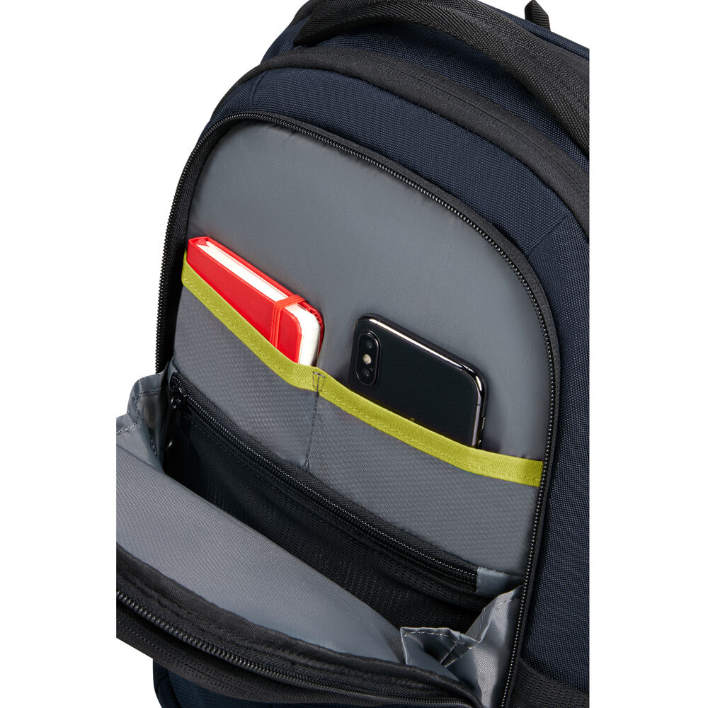 Uno zaino blu navy con una tasca grigia. All'interno della tasca, un taccuino rosso e uno smartphone nero sono visibili.