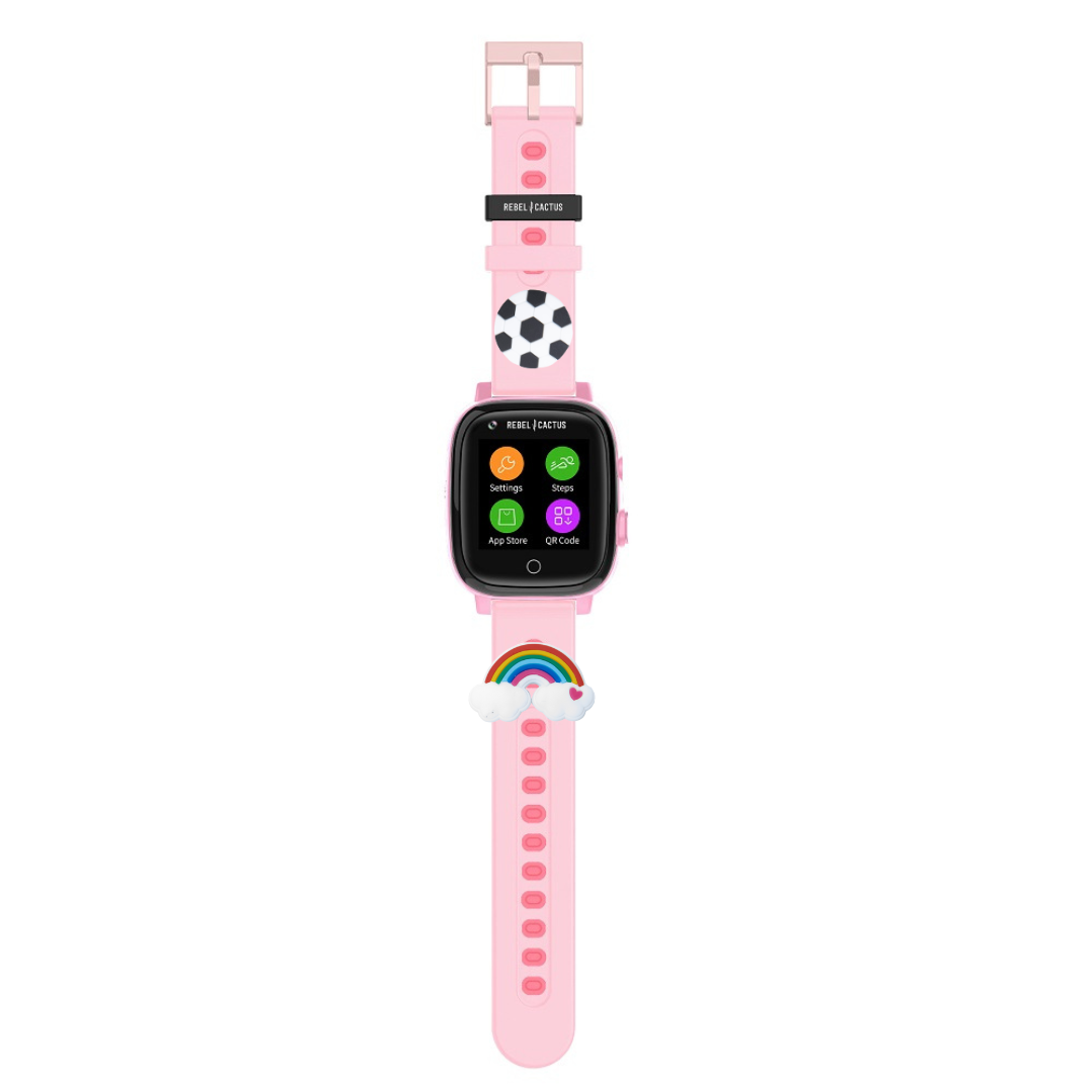 Un reloj inteligente rosa con pantalla negra que muestra ajustes y un código QR. Tiene dijes de balón de fútbol y arcoíris.