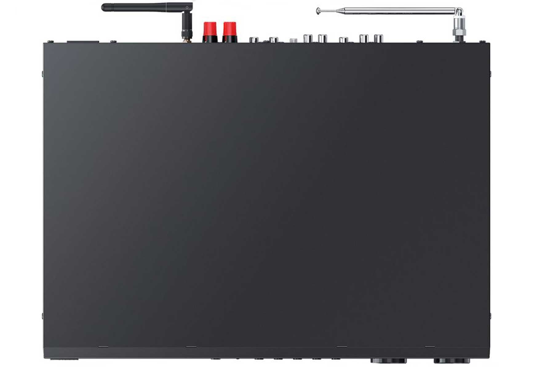 Black audio receiver with antennas and ports. Two red caps are visible. The device sits on a white surface.