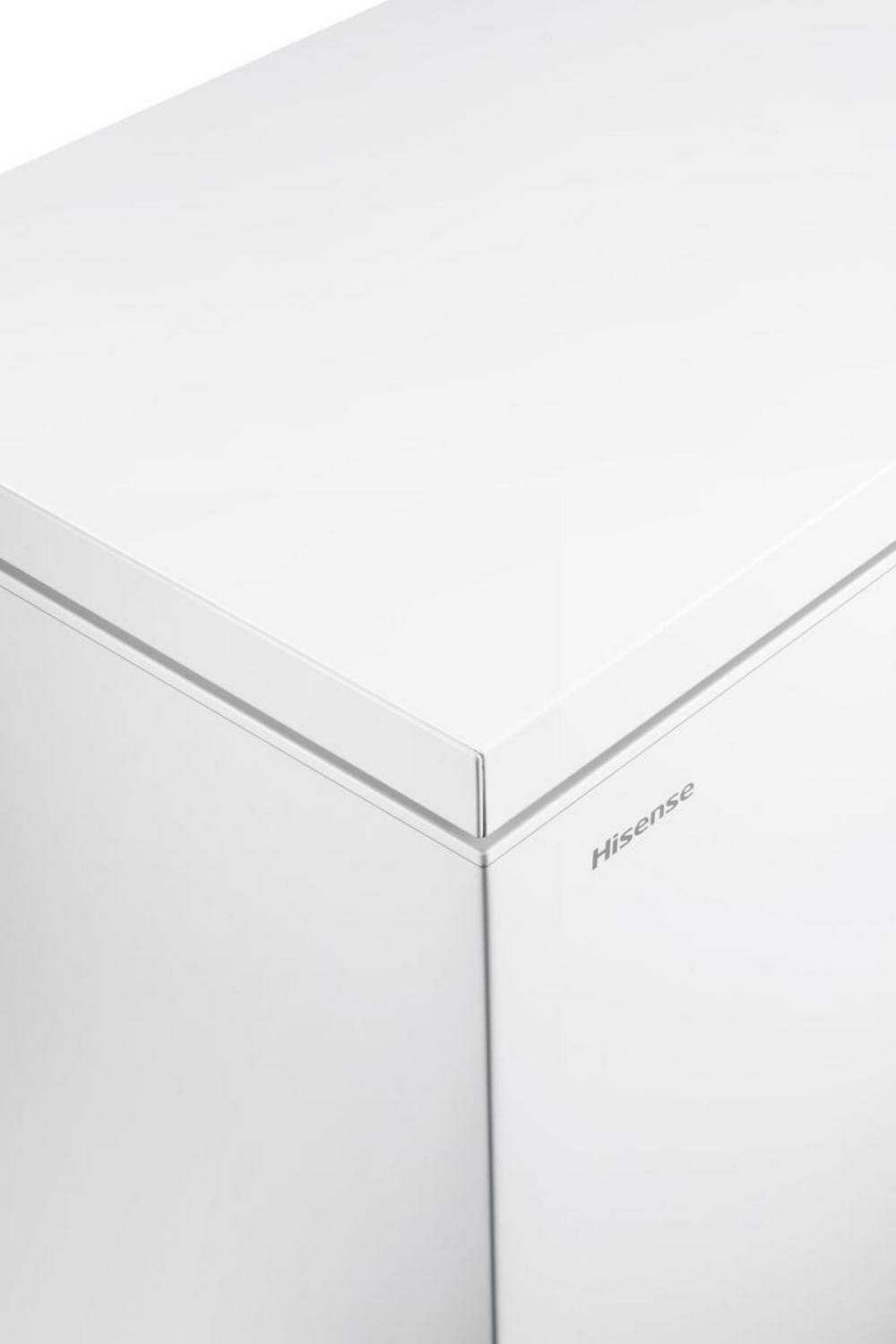 Nahaufnahme eines weißen Hisense-Gefrierschranks. Die Ecke ist sichtbar, mit der Oberseite und Seite, mit Markennamen.