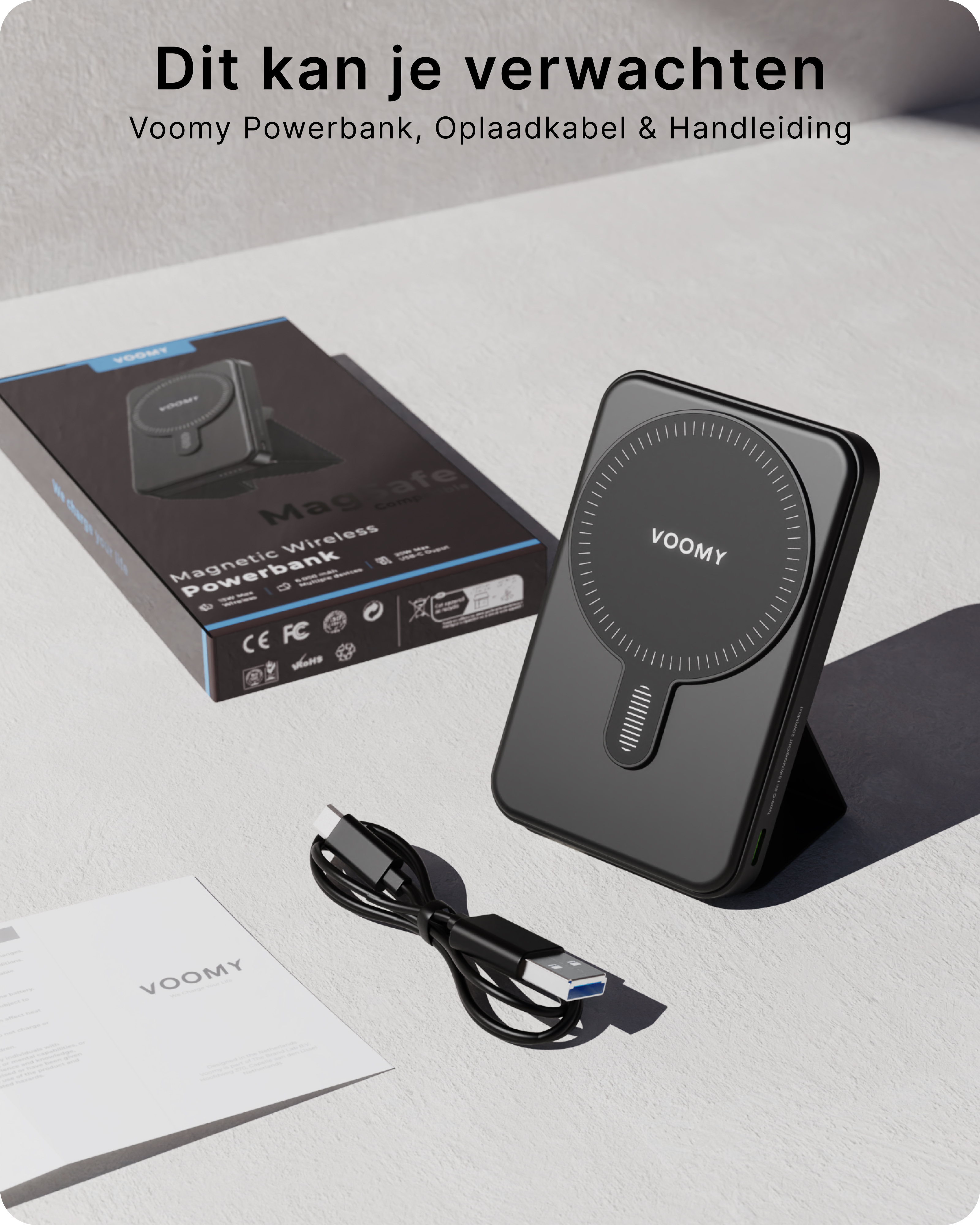 Schwarze Powerbank mit Kabel, Karton und Anleitung auf weißer Oberfläche. Die Powerbank hat den Markennamen VOOMY.
