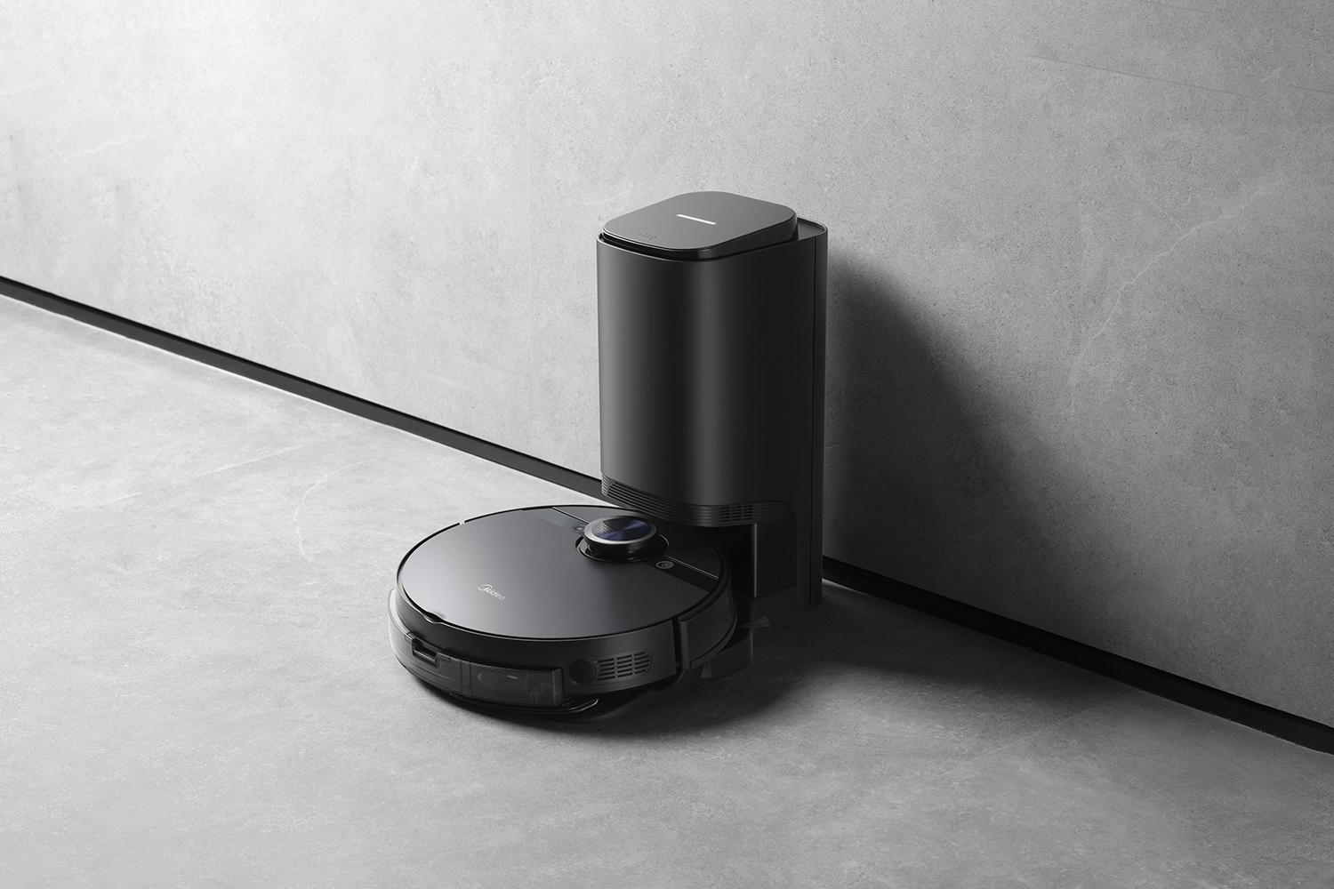 Un aspirateur robot noir et une station de charge sont posés sur un sol gris. La station de charge est haute, l'aspirateur est rond.