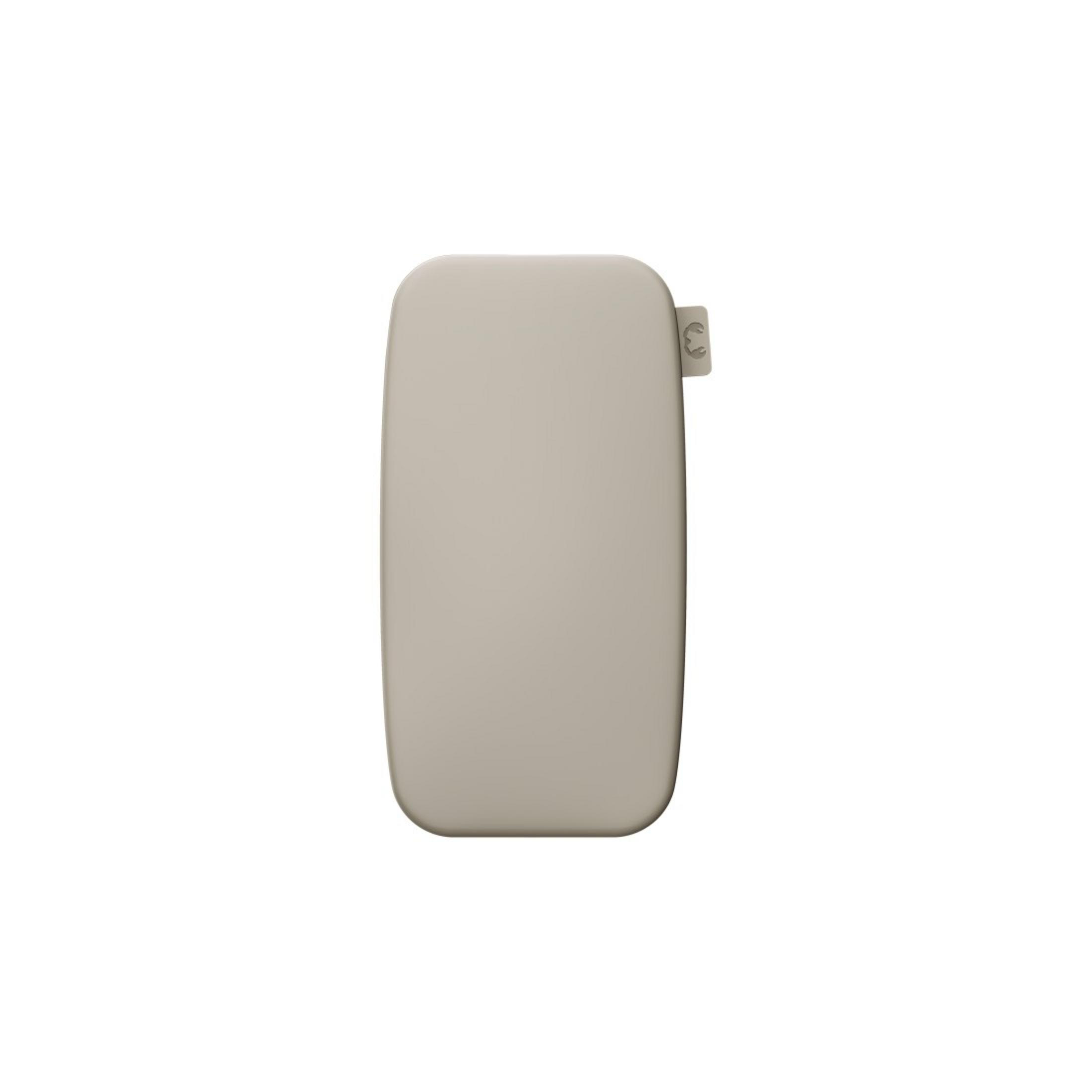 Un oggetto beige, rettangolare con angoli arrotondati, forse una custodia. Ha un piccolo attacco colorato chiaro su un lato.
