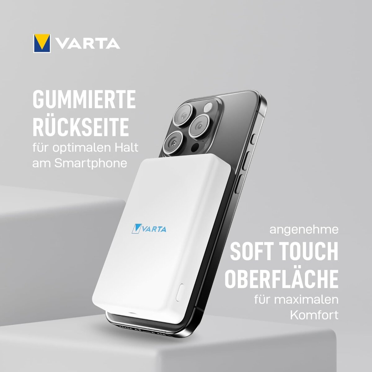 Un power bank Varta bianco attaccato a un telefono nero, su una superficie bianca. Il testo descrive le funzionalità.