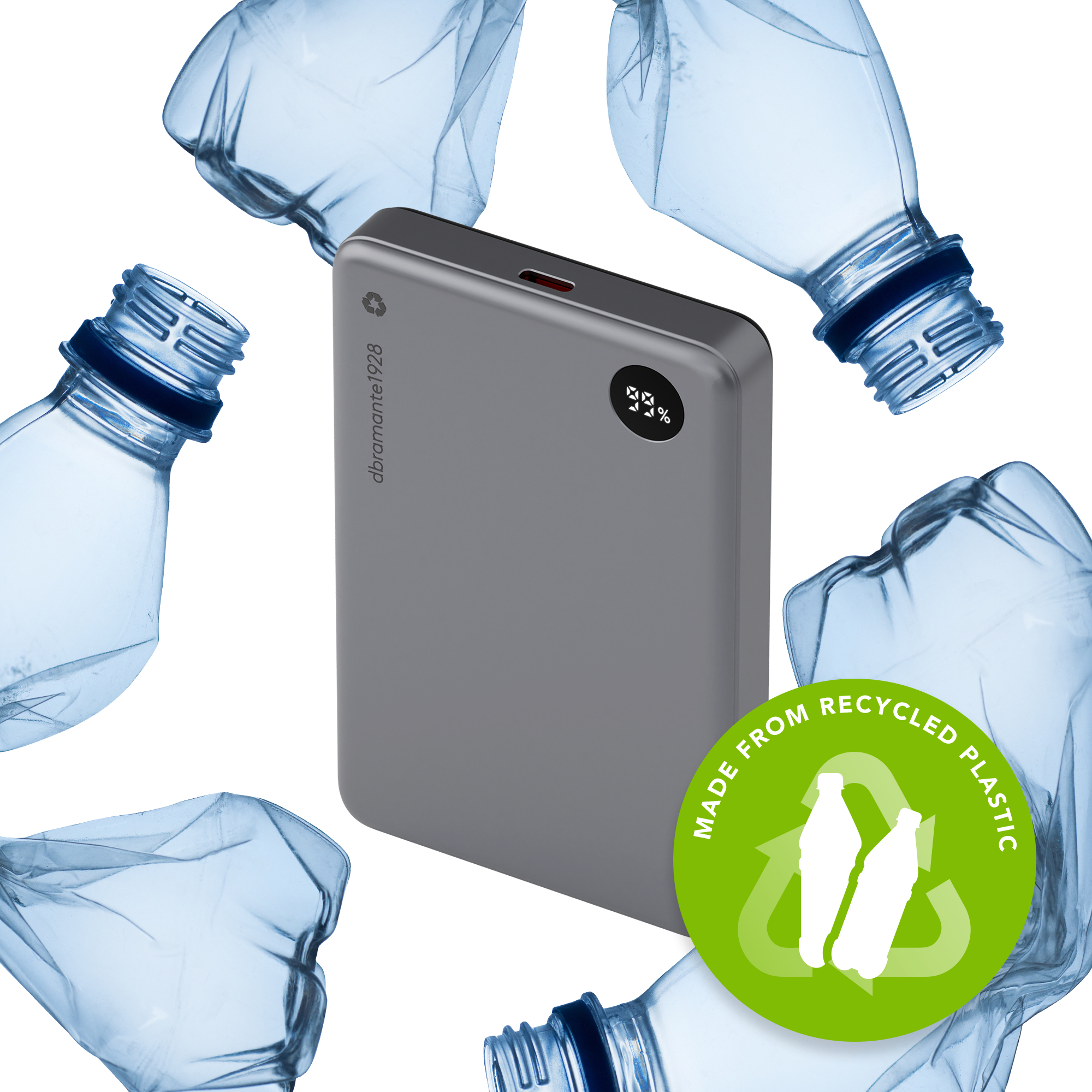 Un power bank grigio circondato da bottiglie di plastica, con un adesivo 'Realizzato con plastica riciclata'.