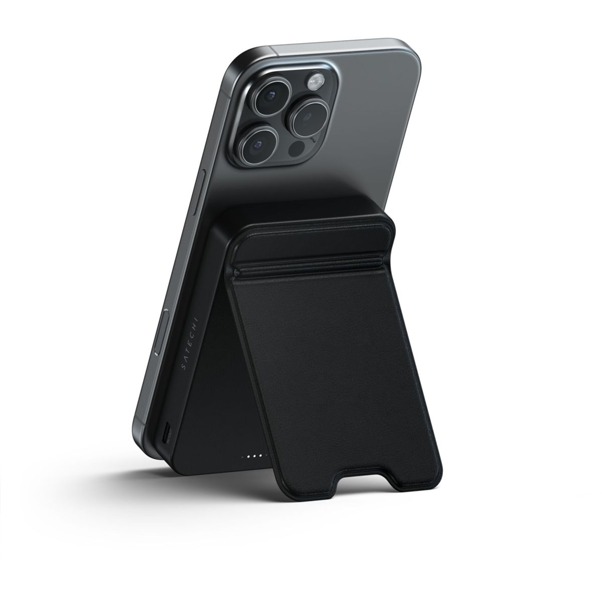 Un iPhone grigio è sostenuto da un supporto nero. Le lenti della fotocamera del telefono sono visibili. Il supporto ha il logo 'Satechi'.