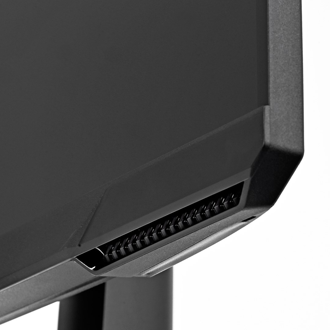 Zbliżenie narożnika czarnego monitora. Pokazuje otwory wentylacyjne, czarną ramkę i część podstawy na białym tle.