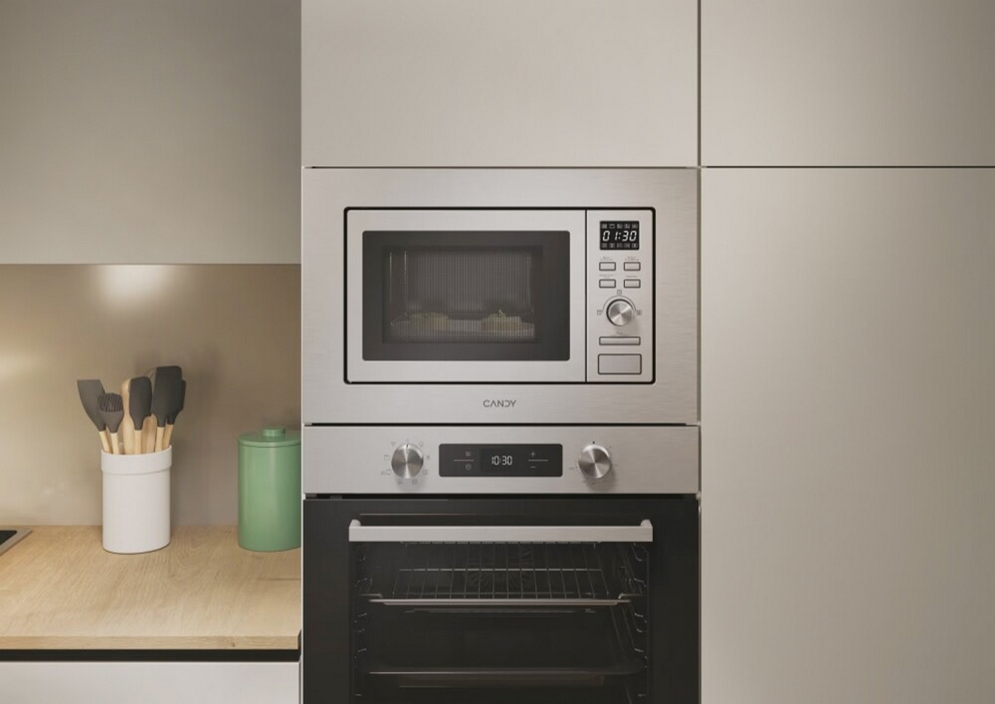 Combinación de microondas y horno de acero inoxidable. Un recipiente blanco con utensilios de cocina. Un recipiente verde en la encimera de madera.