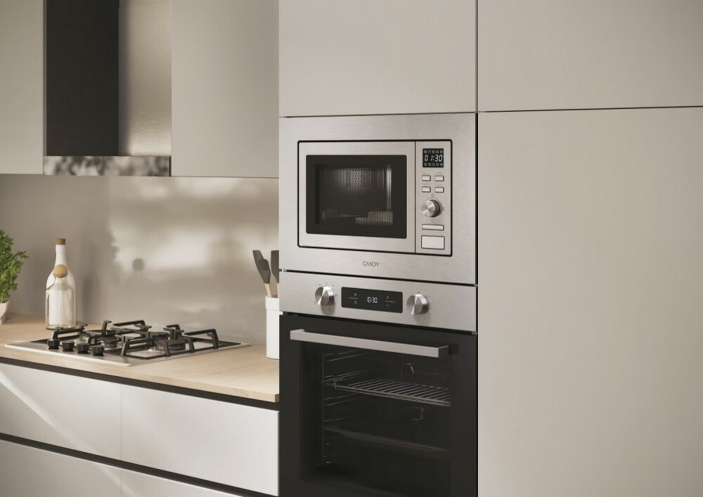 Una cocina moderna con microondas y horno combinados. También son visibles una encimera y armarios. El microondas muestra 01:30.