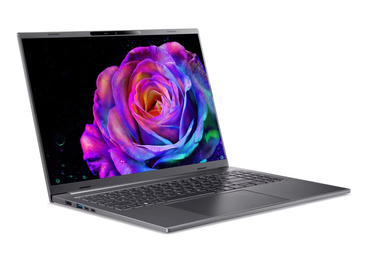 Laptop che mostra una rosa colorata su sfondo nero. Il laptop è grigio e aperto su una superficie bianca.