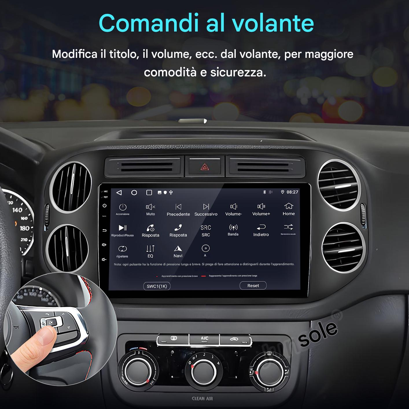 Cruscotto auto con sistema multimediale. Mano preme pulsante volante. Testo: 'Comandi al volante'.