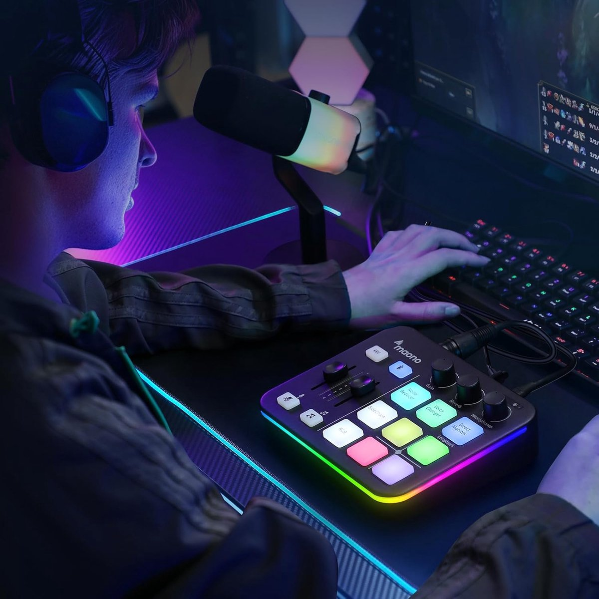 A person wearing headphones is using a mixer, keyboard and microphone setup in a gaming room environment, with colorful lights.