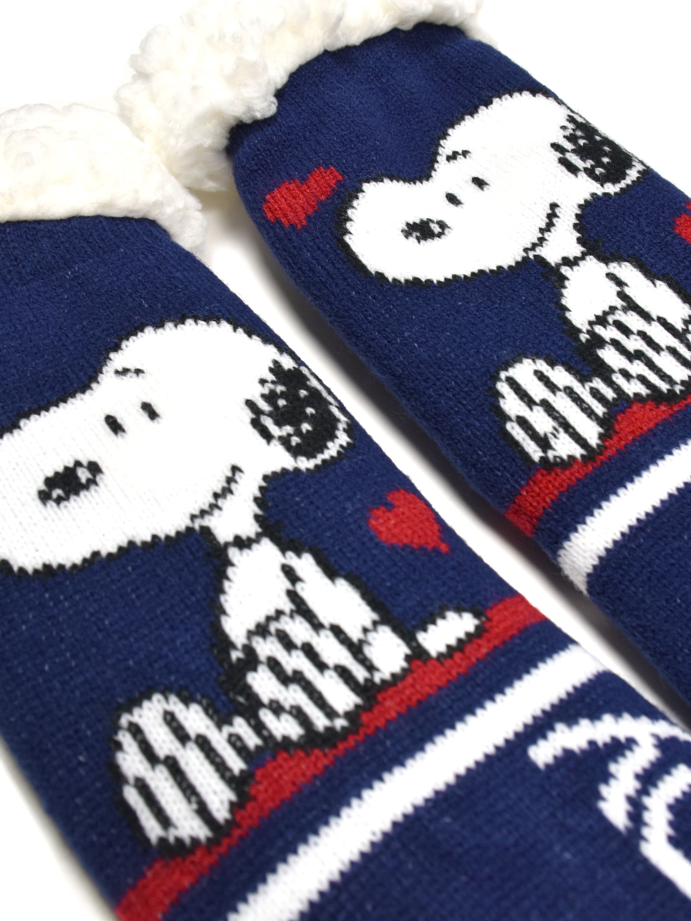 Paar blaue Socken mit Snoopy-Design. Weiße Bündchen, Snoopy's Gesicht, rote Herzdetails auf weißem Hintergrund.