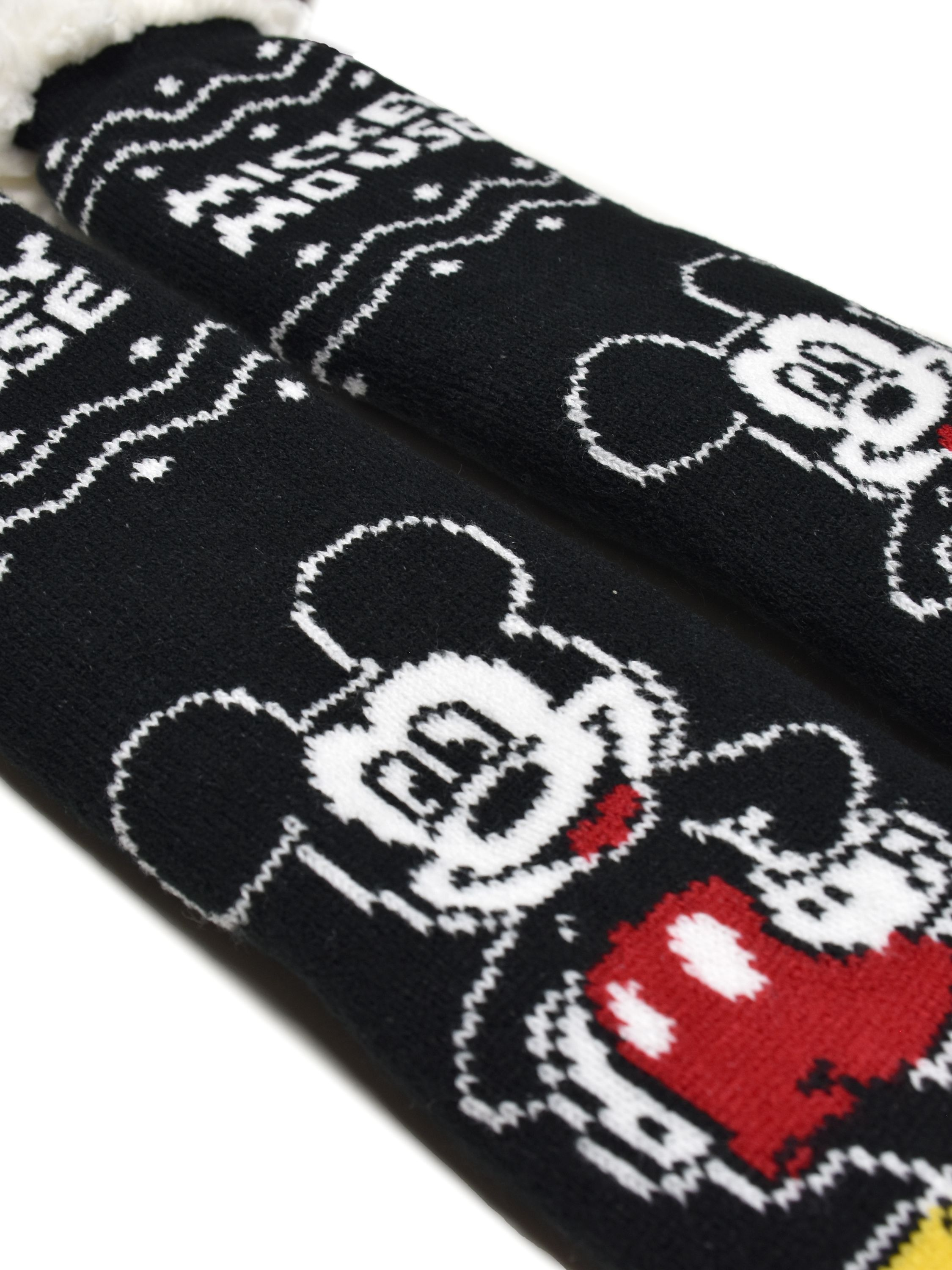 Nahaufnahme von schwarz-weißen Mickey-Mouse-Socken. Mickeys Gesicht und die Worte Mickey Mouse sind sichtbar.