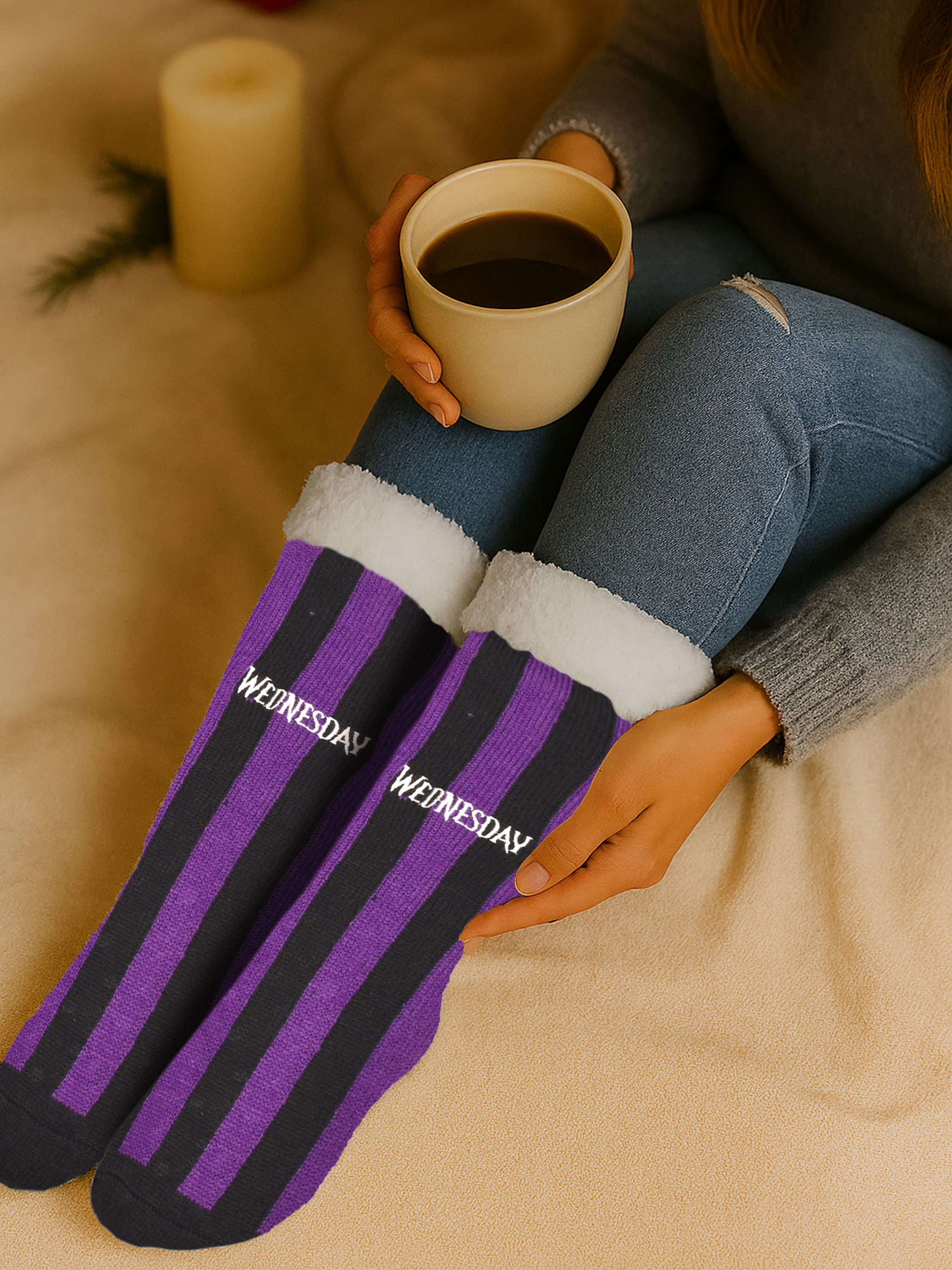 Eine Person hält eine Kaffeetasse und trägt gestreifte Socken mit der Aufschrift 'WEDNESDAY'.