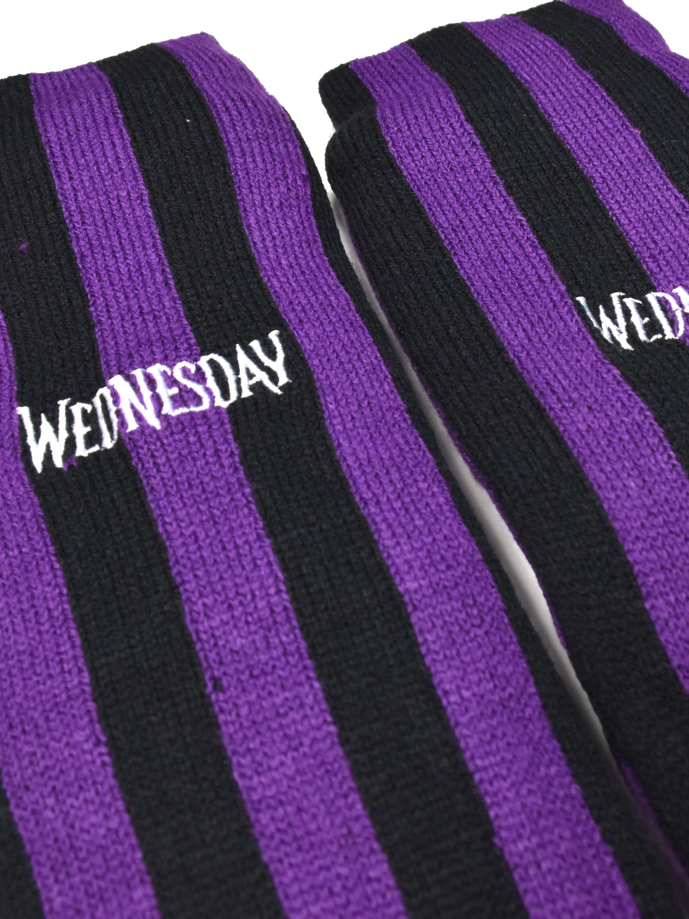 Paar lila-schwarz gestreifte Socken. Auf einer Socke steht 'WEDNESDAY' in weißen Buchstaben.