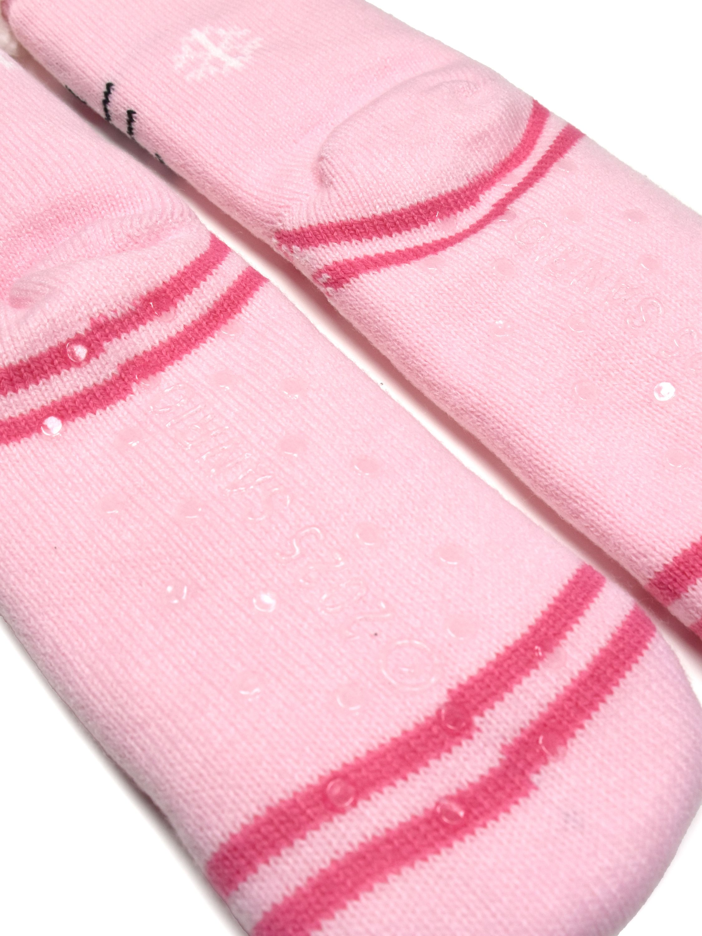 Rosa Socken mit roten Streifen und weißem Schneeflocke. Klare Grip-Punkte befinden sich auf der Unterseite.